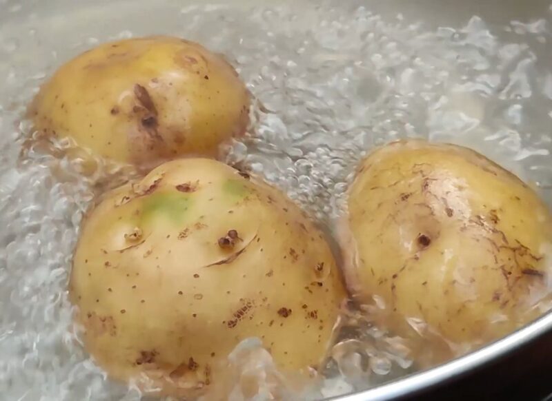 prikaz tri krompira kako se kuvaju u šerpi sa vodom