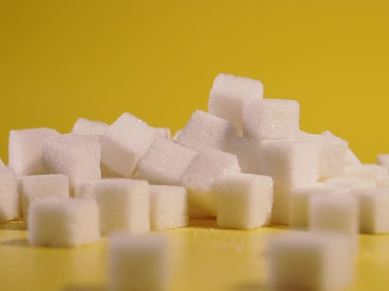 kockice belog šećera na žutoj pozadini