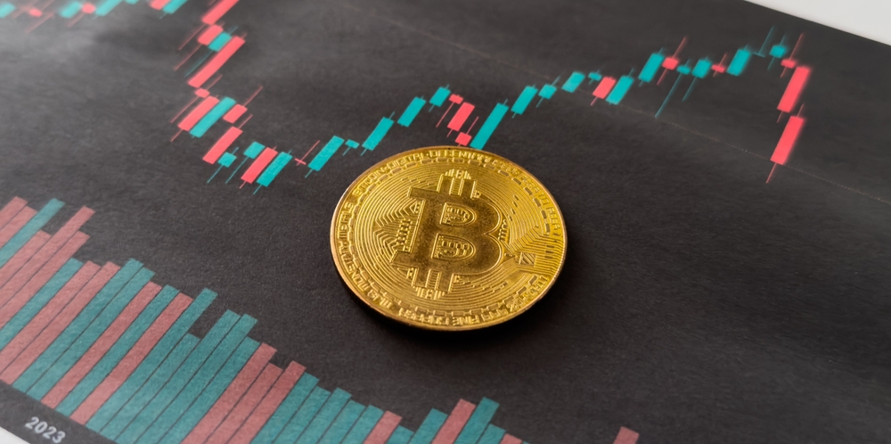 Bitcoin novčić postavljen na grafikon kretanja cene kriptovalute na finansijskom tržištu.