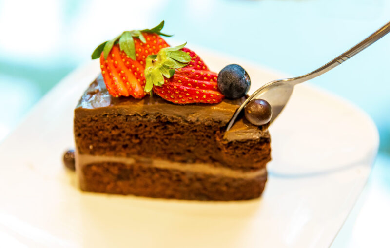 Parče čokoladne torte sa čvrstim biskvitom, kremom i svežim voćem